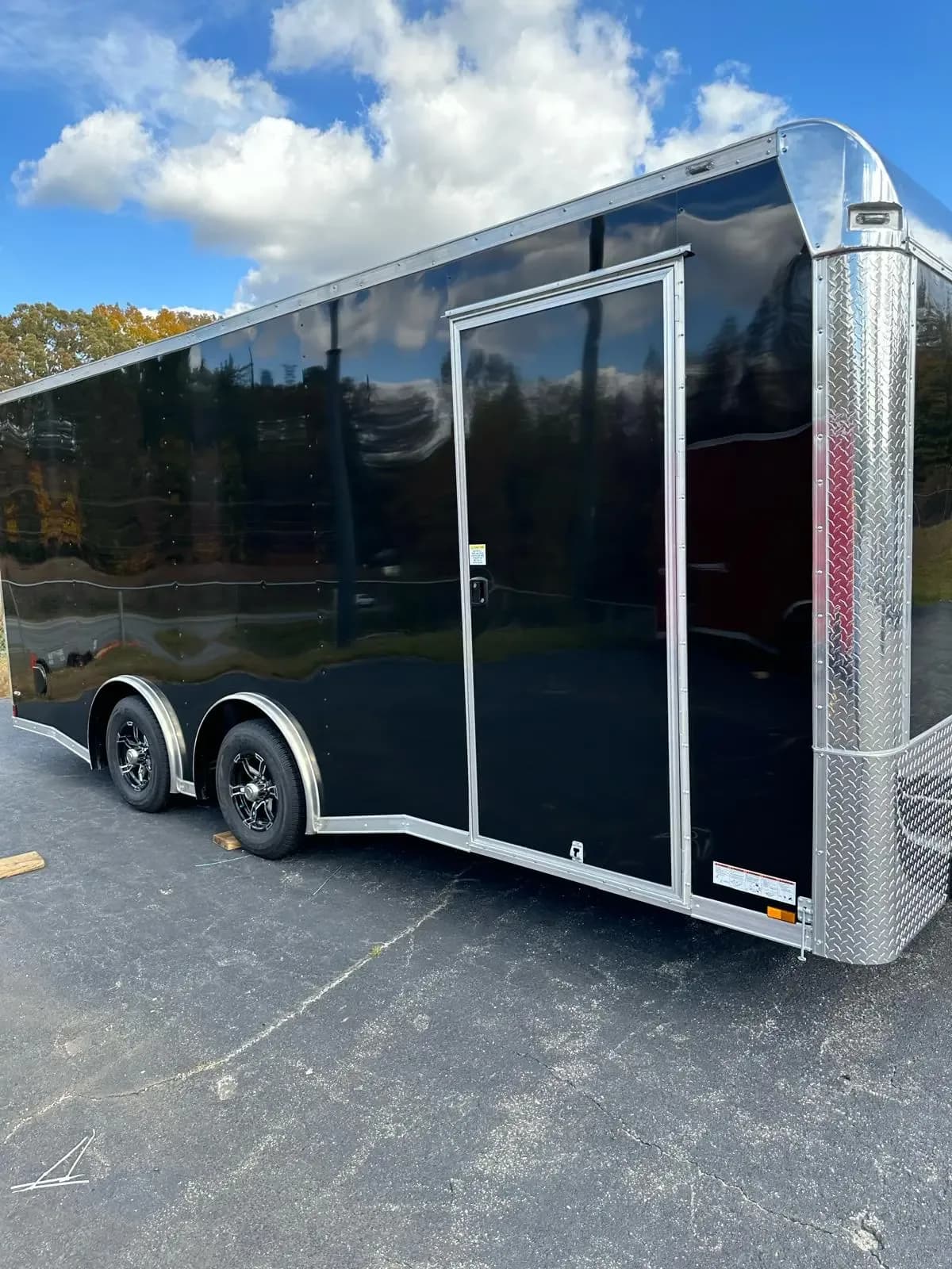 Custom black concession trailer exterior with tandem axles and aluminum trim.